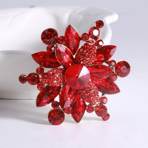 Detail showing the red crystal flower brooch with vintage gold plated alloy and rhinestones