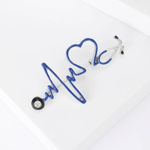 Détail macro de la broche stéthoscope en émail bleu avec ligne ECG et strass brillant