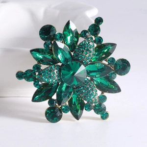 Detailed macro view of vintage emerald green crystal flower brooch with gold alloy base