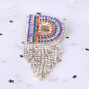 Spilla a lettera D dorata con strass arcobaleno e nappe di cristalli bianchi