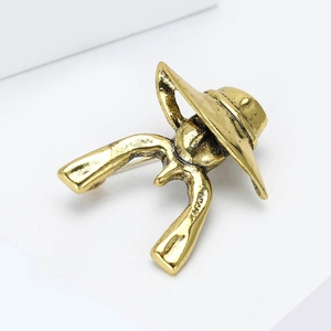 Detail of vintage gold woman silhouette brooch showing textured metal surface