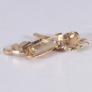 Golden flower cow brooch with enamel detail showing back pin mechanism and metal texture