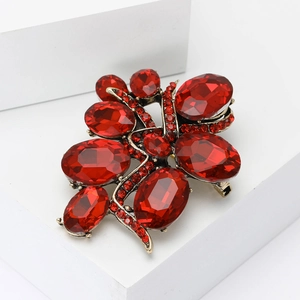 Vintage gold alloy brooch with red faceted gemstones and sparkling rhinestones for suits