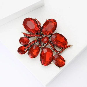 Elegant vintage red ruby brooch with gold alloy base on a white geometric block