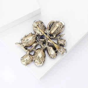 Macro detail of vintage gold floral brooch back with safety pin clasp and rhinestones