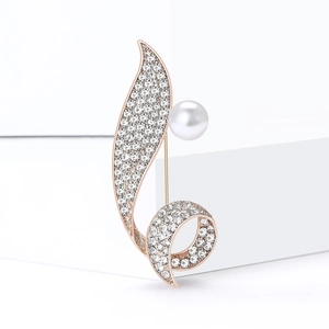 Elegant rose gold rhinestone brooch with leaf design and white pearl on white cube