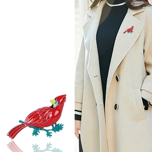 Elegant cardinal bird brooch pin with red enamel finish on a light wool coat lapel