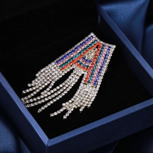 Macro shot of luxury letter A brooch with colorful rhinestones and long silver tassels
