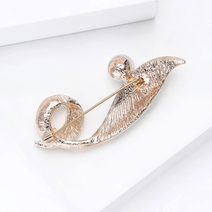 Elegant gold rhinestone brooch with white pearl in a streamlined abstract wave design