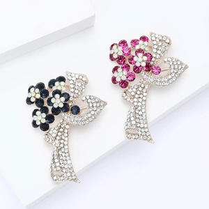 Broche fleur élégante avec cristaux bleus et rouges sur un fond de pierre blanche épuré