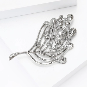 Vue arrière de broche plume argentée montrant le fermoir épingle et texture alliage
