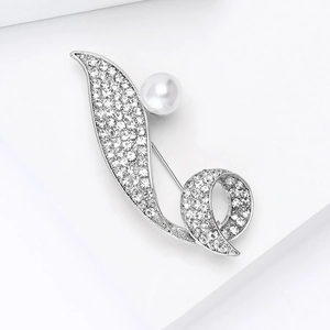 Detail of silver-tone brooch with pavé rhinestones and a white faux pearl accent