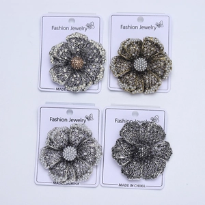 Detail view of retro alloy hollow flower brooches with inlaid white pearls and rhinestones