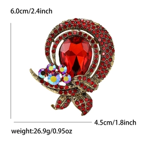 Vintage gold alloy brooch with a large red teardrop crystal and colorful rhinestones