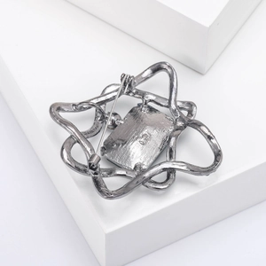 Detail view of the silver star brooch back showing a secure metal pin clasp and frame