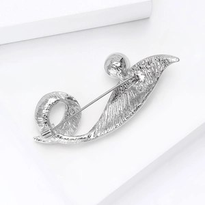Detail view of the silver brooch back showing the pin closure and wavy metal texture
