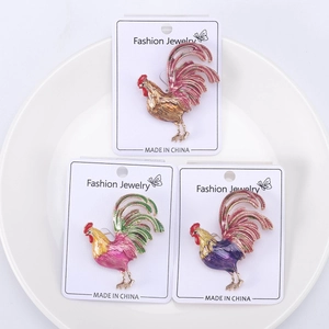 Trois broches coq colorées en émail et alliage, présentées sur des cartes à bijoux