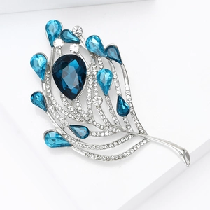 Gros plan d'une broche plume argentée avec cristal bleu et zircon scintillant poli