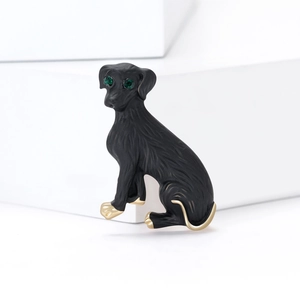 Spilla a forma di cane in smalto nero con occhi in pietra verde e finiture dorate
