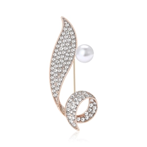 Luxurious rose gold leaf brooch with clear rhinestones and a white pearl on white background