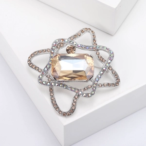Detail of star-shaped brooch with champagne crystals and faceted gemstone on silver base