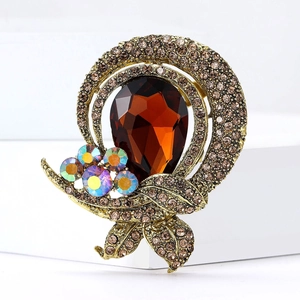 Macro shot of vintage gold-tone brooch with amber pear-cut gem and champagne crystals