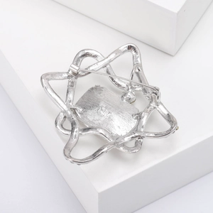 Silver star brooch back detail showing the secure safety pin clasp and brushed metal texture