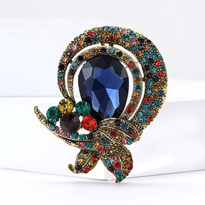 Detailed macro shot of vintage brooch with blue teardrop crystal and colorful rhinestones