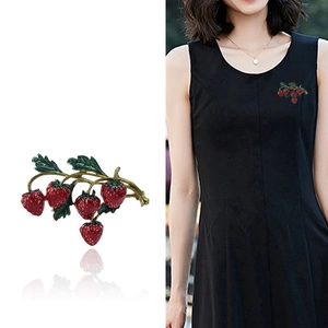 Charmante broche fraise avec fruits en émail rouge et feuilles vertes sur branche dorée
