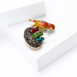 Close-up of woodpecker brooch showing colorful enamel details and crystal accents
