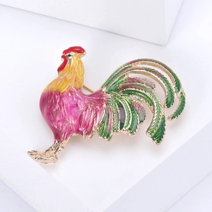 Détail d'une broche coq colorée en émail avec crête rouge et plumes vertes de queue