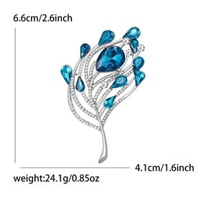 Broche élégante en forme de plume de paon avec strass bleus et finition en argent