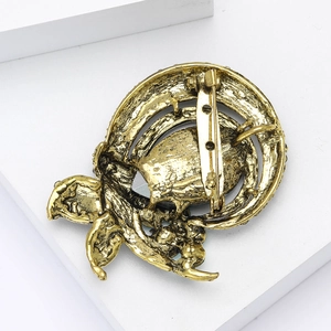 Detail view of the vintage gold alloy brooch back showing the secure pin clasp and floral texture