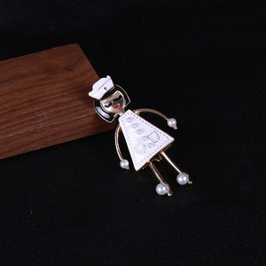 Dettaglio della spilla da infermiera con smalto bianco ed eleganti decorazioni di perle