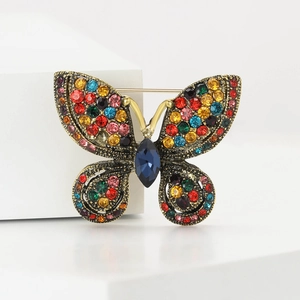 Macro shot of colorful rhinestones and blue drop gem on butterfly brooch wings