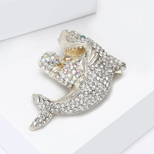 Détail de la broche requin argentée avec strass blancs et AB et un œil en pierre verte