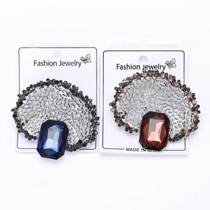 Macro detail of vintage hollow alloy brooches with sparkling blue and amber rhinestones