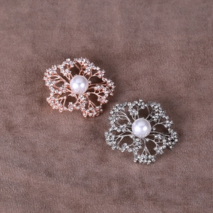 Detailed view of rose gold and silver flower brooches with pearls and crystals