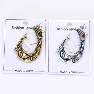 Close-up of vintage fish hook brooches with enamel detailing and intricate patterns