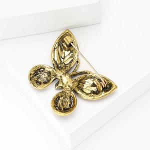 Detail view of butterfly brooch back showing secure pin and vintage gold alloy finish