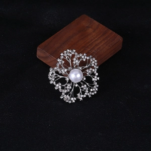 Detail of flower brooch with crystal petals and a large white pearl center