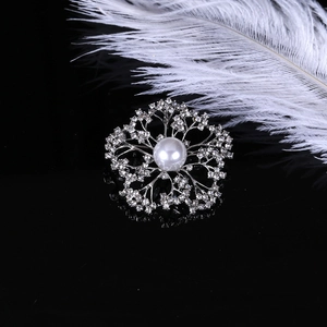 Macro detail of elegant flower brooch with central pearl and diamonds on black background