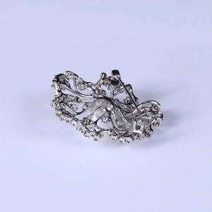 Silver flower brooch with intricate hollow metal design and secure back safety pin closure