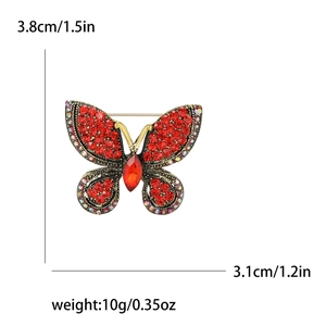 Exquisite gold-tone butterfly brooch with sparkling red rhinestones and crystal details