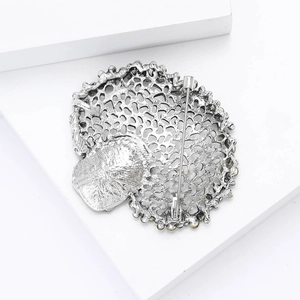 Detail view of vintage hollow peacock brooch back with secure metal pin fastener