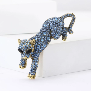Detailed macro view of a leopard brooch with sparkling blue rhinestones on a gold base