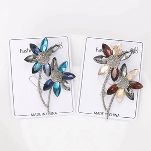 Close-up of elegant crystal flower brooches in blue and gold tones with fine rhinestones