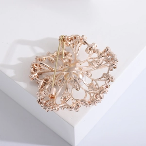 Elegant rose gold hollow flower brooch with a central pearl and diamond accents