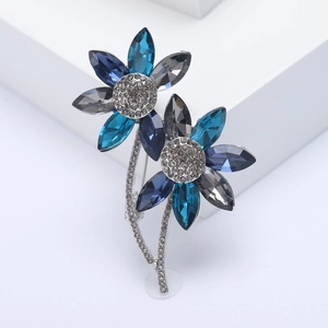 Macro detail of blue crystal flower brooch with silver plating and micro-pave rhinestones