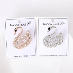 Gros plan de broches cygne élégantes en or rose et argent avec cristaux scintillants
